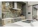 Close-up of a modern kitchen with custom stone backsplash and stainless steel appliances at 2787 La Bella Ct, Henderson, NV 89052