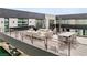 Outdoor terrace with fireplace and comfortable seating with a dining table, lounge chairs, and sofas at 2787 La Bella Ct, Henderson, NV 89052