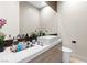 Modern powder room with a white vessel sink, decorative mirror, and sleek vanity at 2787 La Bella Ct, Henderson, NV 89052