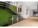 Modern staircase with unique green wall and sleek metal railings, flooded with natural light at 2787 La Bella Ct, Henderson, NV 89052