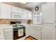 Bright kitchen featuring white cabinetry, a gas range, and a window above the sink that provides natural light at 3125 N Buffalo Dr # 1091, Las Vegas, NV 89128