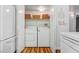 Convenient laundry area featuring a washer, dryer, storage shelf, and close proximity to the refrigerator at 3125 N Buffalo Dr # 1091, Las Vegas, NV 89128