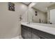 Well-lit bathroom showcasing a gray vanity with a white countertop and a large mirror at 3217 Bertonico Ave, Henderson, NV 89044