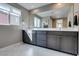 Modern bathroom featuring a double sink vanity with sleek gray cabinets and a large mirror at 3217 Bertonico Ave, Henderson, NV 89044