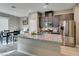 A modern kitchen features granite counters, stainless steel appliances, and a dining table with black chairs at 3217 Bertonico Ave, Henderson, NV 89044