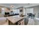 Open-concept kitchen featuring granite countertops, a large island, and a view of the comfortable living area at 3217 Bertonico Ave, Henderson, NV 89044