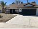 Charming single-story home featuring a gravel yard, black garage door, and unique stone accents at 3409 El Cortez Ave, Las Vegas, NV 89102