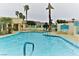 Community pool area featuring crystal clear water, blue lounge chairs, palm trees, and desert mountain views at 3550 Bay Sands Dr # 2016, Laughlin, NV 89029