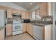 A well-lit kitchen features white appliances and granite countertops, with tile backsplash at 3750 Horseshoe Mesa St, Las Vegas, NV 89147