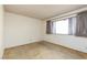 This bedroom has beige carpet, white walls and a window with patterned curtains at 3871 Sinclair St, Las Vegas, NV 89121