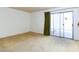 The bedroom includes beige carpeting and a sliding glass door with green drapes at 3871 Sinclair St, Las Vegas, NV 89121