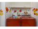A vintage laundry room features a classic red washer and dryer with flower decals on the surrounding walls at 3871 Sinclair St, Las Vegas, NV 89121