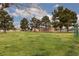 A large grassy field with a playground and mature trees in a neighborhood at 3871 Sinclair St, Las Vegas, NV 89121