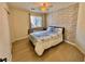 Bright bedroom with a ceiling fan, patterned accent wall, and laminate wood flooring at 4046 Sparrow Rock St, Las Vegas, NV 89129