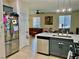 Open kitchen with stainless steel refrigerator, quartz countertops, and a view of the living area at 4046 Sparrow Rock St, Las Vegas, NV 89129
