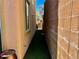 Narrow side yard with artificial turf and a view of neighboring houses at 4046 Sparrow Rock St, Las Vegas, NV 89129