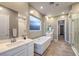 Bright bathroom featuring double sinks, soaking tub, and large walk-in shower at 51 Reflection Cove Dr, Henderson, NV 89011