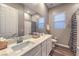 Bathroom featuring double sinks, large mirror, and tiled shower-tub combination at 51 Reflection Cove Dr, Henderson, NV 89011