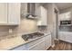 Modern kitchen featuring granite countertops, a gas cooktop, and sleek white cabinetry at 51 Reflection Cove Dr, Henderson, NV 89011