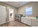 Well-lit laundry room featuring stainless steel washer and dryer, sink, and ample counter space at 51 Reflection Cove Dr, Henderson, NV 89011