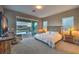 Spacious main bedroom with backyard views and access, neutral carpet, and stylish furnishings at 51 Reflection Cove Dr, Henderson, NV 89011