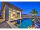 Stylish backyard with a sparkling pool, covered patio, and desert landscaping, perfect for outdoor relaxation at 51 Reflection Cove Dr, Henderson, NV 89011