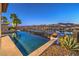 Tranquil outdoor space with an infinity pool reflecting palm trees and an open view of the city and mountains at 51 Reflection Cove Dr, Henderson, NV 89011