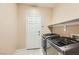 Convenient laundry room includes modern washer and dryer set and shelving for storage at 5505 Criollo Dr, Las Vegas, NV 89122