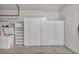 Garage features ample storage with white cabinets and shelving and an upright freezer at 570 Cypress Gardens Pl, Henderson, NV 89012