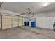 Spacious garage with ample storage featuring a large door, shelving, and cabinets at 570 Cypress Gardens Pl, Henderson, NV 89012
