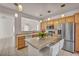 Kitchen features a kitchen island, stainless steel refrigerator, microwave, and ample counter space at 570 Cypress Gardens Pl, Henderson, NV 89012