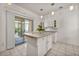 Bright kitchen featuring a kitchen island, white cabinets, and sliding glass door to the outdoors at 570 Cypress Gardens Pl, Henderson, NV 89012