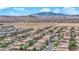 Sprawling aerial view of a dense residential neighborhood set against a backdrop of majestic mountains and desert landscape at 6217 Lone Cypress Ct, Las Vegas, NV 89141