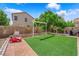 Backyard oasis with verdant artificial grass and thoughtful hardscape design at 6217 Lone Cypress Ct, Las Vegas, NV 89141