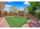 A lush backyard featuring artificial turf and mature landscaping at 6217 Lone Cypress Ct, Las Vegas, NV 89141