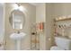 Charming bathroom with pedestal sink, decorative shelving, and neutral color scheme at 6217 Lone Cypress Ct, Las Vegas, NV 89141