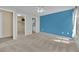 Bright bedroom with blue accent wall leading to a walk-in closet and attached bathroom at 6217 Lone Cypress Ct, Las Vegas, NV 89141