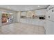 Bright kitchen featuring white cabinets, tile backsplash, and sliding glass door access to the backyard at 6217 Lone Cypress Ct, Las Vegas, NV 89141