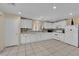 Well-lit kitchen with white cabinetry, tile floors, contrasting backsplash, and modern appliances at 6217 Lone Cypress Ct, Las Vegas, NV 89141