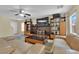 Open-concept living room featuring tile flooring, comfortable couches, and a custom entertainment center at 6217 Lone Cypress Ct, Las Vegas, NV 89141