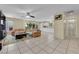 Spacious open-concept living area with tile flooring and neutral paint, seamlessly blending the living room and kitchen at 6217 Lone Cypress Ct, Las Vegas, NV 89141