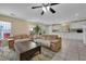 Inviting living area with comfortable sofas, tile flooring, and open layout, merging the living room with the kitchen at 6217 Lone Cypress Ct, Las Vegas, NV 89141