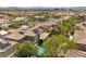 Aerial view of a home with a red tile roof, solar panels, and a sparkling pool in a vibrant community at 631 Coriander Canyon Ct, Las Vegas, NV 89138