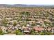 A wide community view of terracotta-roofed houses interspersed with greenery, palm trees and convenient access to roadways at 631 Coriander Canyon Ct, Las Vegas, NV 89138