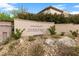 A stone entryway features a community sign for Serrano nestled in a rock garden with shrubs and stone walls at 631 Coriander Canyon Ct, Las Vegas, NV 89138