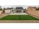 Large backyard featuring lush artificial grass, covered patio and solar panels at 6549 Gazelle Dr, Las Vegas, NV 89108