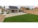 Backyard featuring lush artificial grass, covered patio and solar panels at 6549 Gazelle Dr, Las Vegas, NV 89108