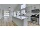 Bright kitchen featuring white cabinets, quartz countertops, stainless steel appliances, and wood-look tile flooring at 6549 Gazelle Dr, Las Vegas, NV 89108