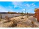 A spacious backyard, enclosed by a fence, features desert landscaping and potential for a tranquil outdoor retreat at 6661 Gallup Ct, Pahrump, NV 89060