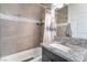 Bright bathroom featuring tiled shower with gray vanity and granite countertop at 6661 Gallup Ct, Pahrump, NV 89060